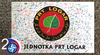 Podepsaná vlajka se znakem 9. jednotky PRT Logar
